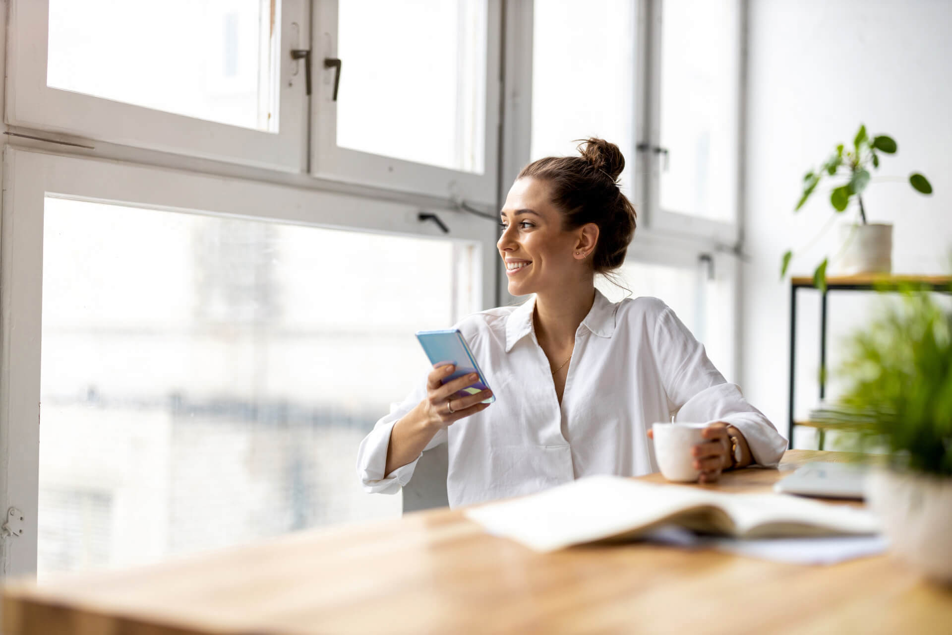 Kobieta z telefonem przy biurku &mdash; m4eGroup